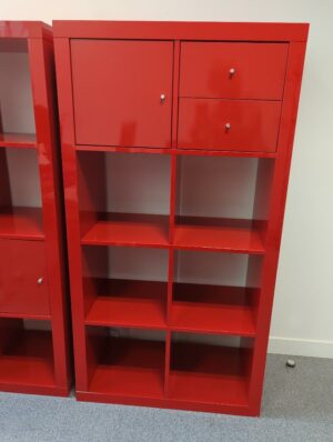 Bibliothèque en bois laqué rouge à 8 compartiments dont un ouvrant par une porte et un ouvrant par deux tiroirs, divers modèles.. 150 x 80 x 40 cm. 
unités : 16
es5, 1-34, 1-31, 1-16, 2-53, 2-48, 2-47, 2-61, 2-68, 3-95, 3-85