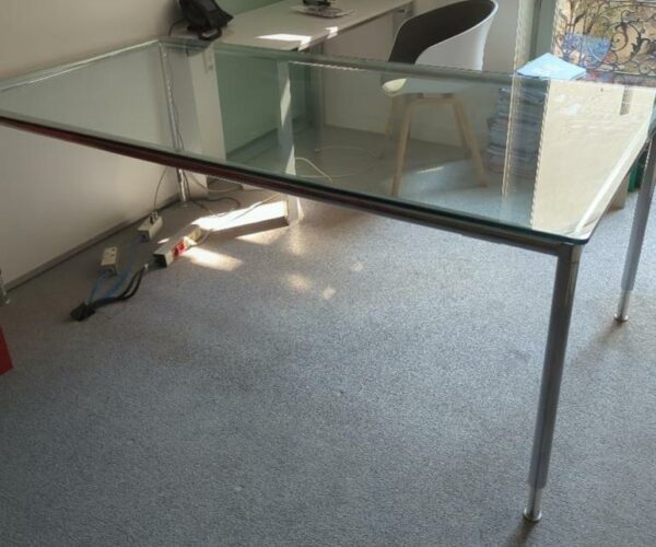 Table ou bureau de marque Bosse modèle Modul Space, plateau rectangulaire en verre transparent reposant sur une structure en acier chromé, pieds réglables en hauteur. 76 x 200 x 100 cm. Localisation : 6 rue Duret - 75116 Paris : 1-21