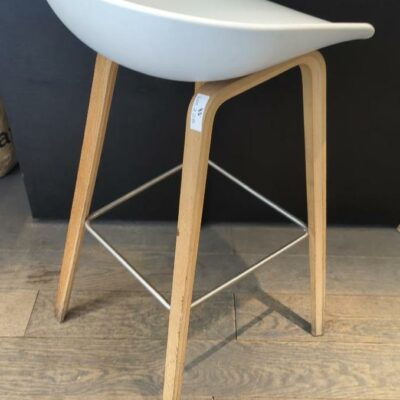 Tabouret haut design Hee Welling modèle About A Stool édition Hay coque en polypropylène blanc sur un piétement en bois naturel avec repose pied. en métal. 84 x 43 x 43 cm.  4 unités. Vendu à l’unité avec faculté de réunion Localisation :  rdc