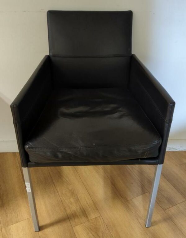 Fauteuil design Karl Friedrich Foster modèle Texas édition KFF recouvert de cuir noir, piètement en acier à section carrée, assise amovible. 86 x 53 x 53 cm. 26 unités. Vendu à l'unité avec faculté de réunion. Localisation : 6 rue Duret - 75116 Paris :  -1 salle à manger, 2eme bas, -2 vestiaire