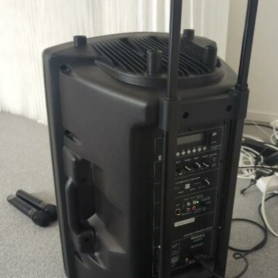 Enceinte portable sur roulettes de marque Ibiza modèle Port15UHF-BT + 2 micros sans fil modèle Port-UHF. 65 x 42 x 35 cm. Localisation : 6 rue Duret – 75116 Paris : salle réunion -2