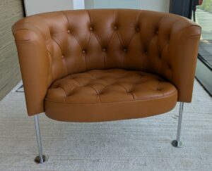 Fauteuil design Trix & Robert Haussmann modèle Haussmann édition Walter Knoll, revêtement en cuir capitonné marron, piètement en acier tubulaire chromé sur patins. 70 x 72 x 85 cm. Localisation : 7 ouest (7712)