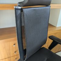 Fauteuil de direction pivotant ajustable avec tétière de marque TALIN, structure en acier chromé, dossier en résille, garniture en cuir marron foncé, piètement en étoile à 5 branches sur roulettes. Localisation : 7 ouest (7712) – Image 3