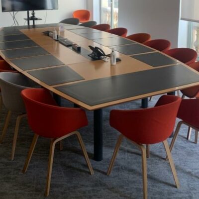 Table de réunion, en bois, avec un plateau en forme de tonneau, trappes techniques et surfaces antidérapantes noires, sur piétements en métal.
72 x 480 x 220 cm.
Localisation : 6 rue Duret – 75116 Paris, 
(RDC haut salle Pékin.)