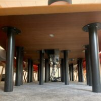 Table de réunion, en bois, avec un plateau en forme de tonneau, trappes techniques et surfaces antidérapantes noires, sur piétements en métal.
72 x 480 x 220 cm.
Localisation : 6 rue Duret - 75116 Paris, 
(RDC haut salle Pékin.) – Image 4
