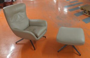 Fauteuil de direction pivotant design Rodolfo Dordoni modèle Jensen édition Minotti recouvert de cuir beige, piètement en étoile à 4 branches en acier laqué noir, avec son ottoman. Dimension fauteuil : 93 x 82 x 78 cm. Dimension ottoman : 35 x 60 x 60 cm. Localisation : 5 avenue Kleber - 75116 Paris