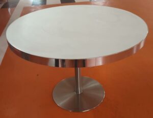 Table ronde plateau en bois stratifié et verre fumé blanc cerclé d'inox reposant sur un piètement en acier chromé. 74 x 111 cm. 7 unités. Vendu à l'unité avec faculté de réunion. Localisation : 5 avenue Kleber - 75116 Paris