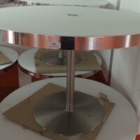 Table ronde avec trappe technique centrale, plateau en bois stratifié et verre fumé blanc cerclé d'inox reposant sur un piètement en acier chromé. 74 x 111 cm. 7 unités. Vendu à l'unité avec faculté de réunion. Localisation : 5 avenue Kleber - 75116 Paris – Image 3
