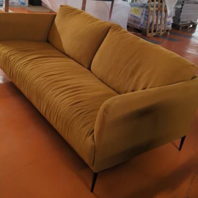 Canapé 4-5 places recouvert de tissu ocre,  dossiers amovibles et déhoussables, piétement en acier laqué noir. 82 x 200 x 60 cm. Localisation : 5 avenue Kleber – 75116 Paris