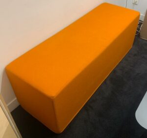 Banquette de marque Buzzi Space modèle Buzzi Cube recouverte de tissu orange mandarine. 46 x 138 x 47 cm. Localisation : 10 rue Petit - 75019 Paris (1er)