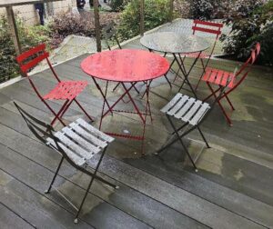 Ensemble de 2 tables et de 6 chaises de marque Fermob en métal dont une table et 3 chaises de couleur rouge, et une table et 3 chaises de couleur gris taupe. Localisation : 6 rue Duret - 75116 Paris