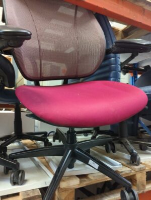 Fauteuil de bureau ergonomique de marque Humanscale modèle Liberty, assise en tissu rose, dossier résille, piètement sur roulettes en métal noir. 100 x 68 x 47 cm. Localisation : 10 rue du Ballon - 93160 Noisy-le-Grand