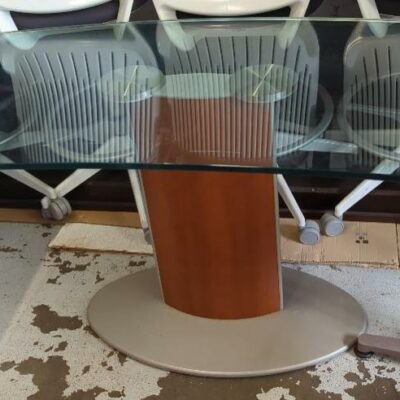 Bureau plateau de forme concave en verre transparent reposant sur un pied central en bois et métal. 73 x 134 x 70 cm. Localisation : 10 rue du Ballon – 93160 Noisy-le-Grand