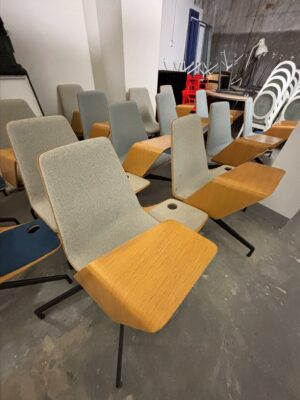 Fauteuil de conférence de marque Haworth, modèle Harbor Work Chair recouverte de tissu gris clair chiné, piétement en métal noirci mat et tablette de travail et bois de type chêne clair. 15 unités vendues avec faculté de réunion.