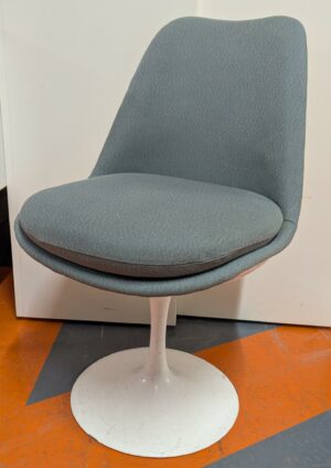 Chaise dans le goût du modèle Tulip Chair de Eero Saarinen, coque en plastique blanc, garniture en tissu bleu gris clair, coussin d'assise amovible, piétement en acier laqué blanc. 81 x 50 x 66 cm. 2 unités. Vendu à l'unité avec faculté de réunion. Localisation : 5 avenue Kleber - 75116 Paris