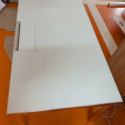 Bureau rectangulaire de marque Unifor, plateau en bois stratifié et verre avec trappe technique, piètement chromé. 74 x 140 x 80 cm. Localisation : 5 avenue Kleber – 75116 Paris