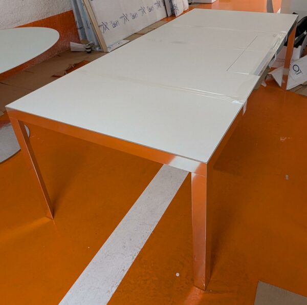 Bureau rectangulaire de marque Unifor, plateau en bois stratifié blanc avec trappe technique, piètement chromé. 74 x 220 x 100 cm. Localisation : 5 avenue Kleber - 75116 Paris