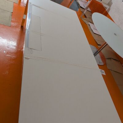 Bureau rectangulaire de marque Unifor, plateau en bois stratifié blanc avec trappe technique, piètement chromé. 74 x 220 x 100 cm. Localisation : 5 avenue Kleber – 75116 Paris