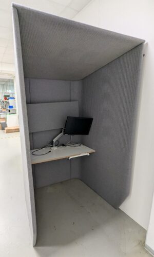 Cabine acoustique de marque Buzzi Space recouverte de feutrine grise, tablette en bois avec prise électrique. 218 x 125 x 120 cm. (SS bat A)