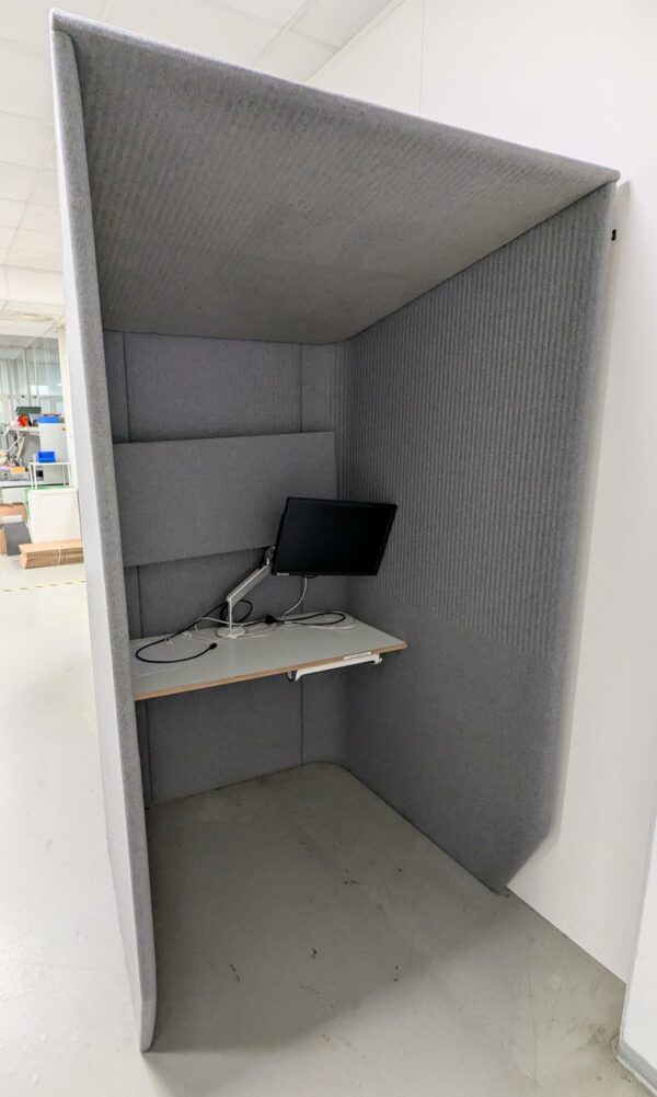 Cabine acoustique de marque Buzzi Space recouverte de feutrine grise, tablette en bois avec prise électrique. 218 x 125 x 120 cm. (SS bat A)