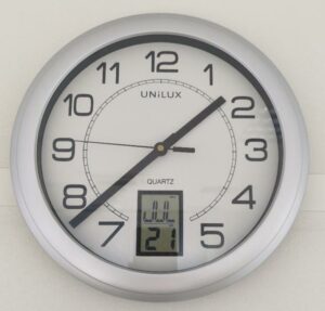Horloge murale à quartz de marque Unilux modèle Instinct, avec dateur digital, cadre gris. 17 unités. Vendu à l'unité avec faculté de réunion. (1er bat A : 8 / RDC bat A : 7 / SS bat A : 1 / Bat B : 1)