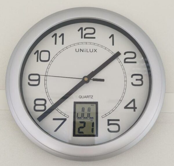 Horloge murale à quartz de marque Unilux modèle Instinct, avec dateur digital, cadre gris. 17 unités. Vendu à l'unité avec faculté de réunion. (1er bat A : 8 / RDC bat A : 7 / SS bat A : 1 / Bat B : 1)