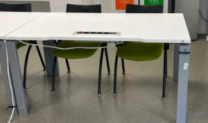 Bureau droit blanc avec prise électrique, piètement gris. 72 x 140 x 80 cm.
13 unités.